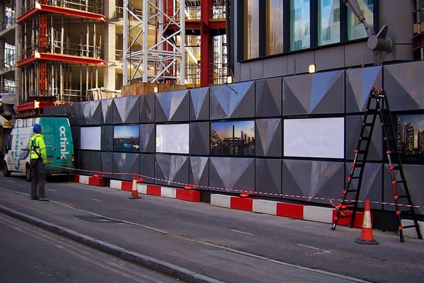 Octink installer surveying a hoarding